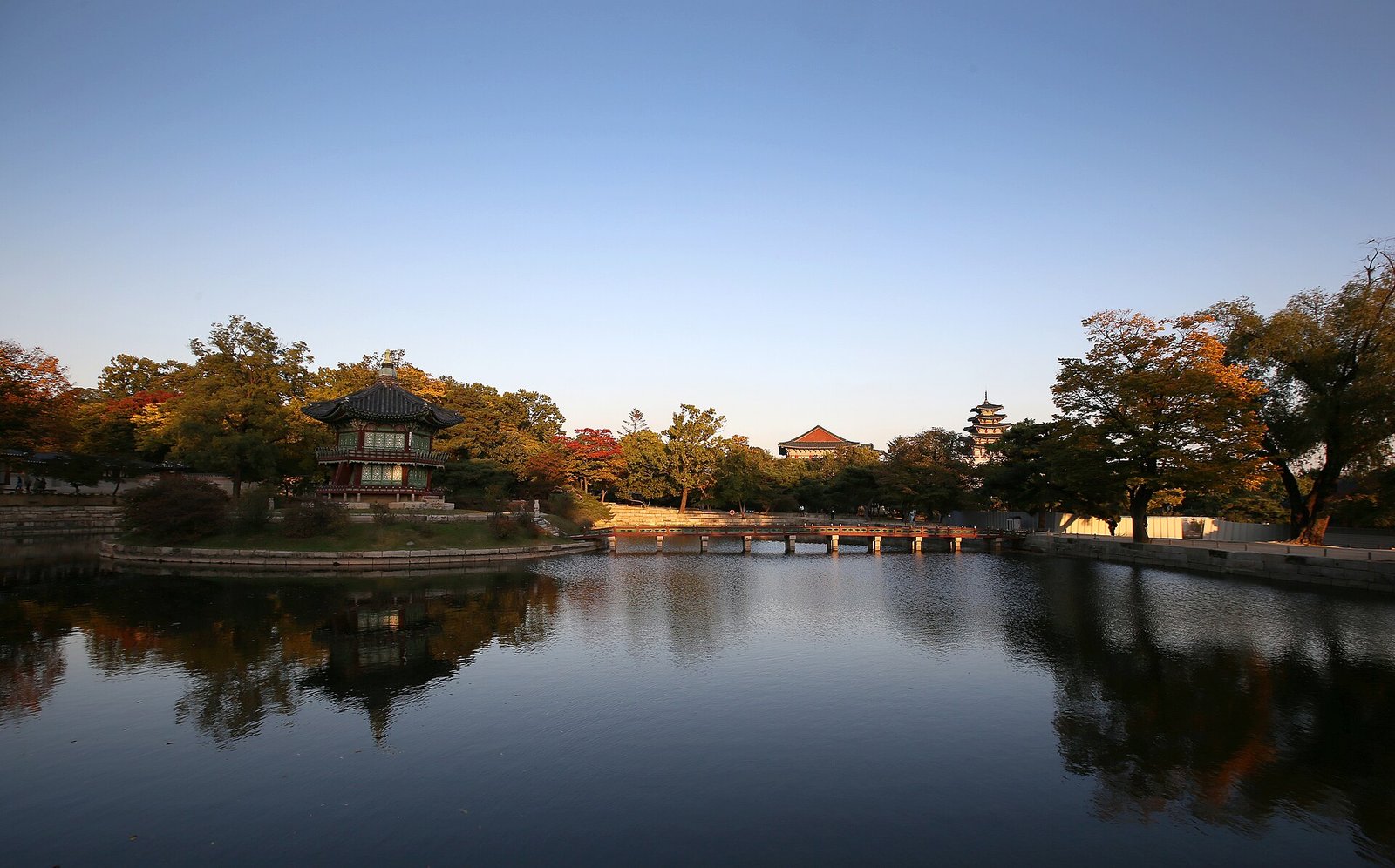 Hyangwonjeong pavilion and its pond at Gyeongbokgung with autumn trees at dusk