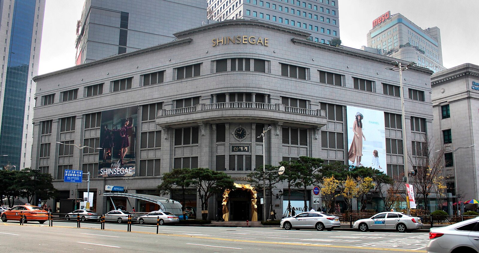 The stone front of a department store main building in central Seoul with taxis