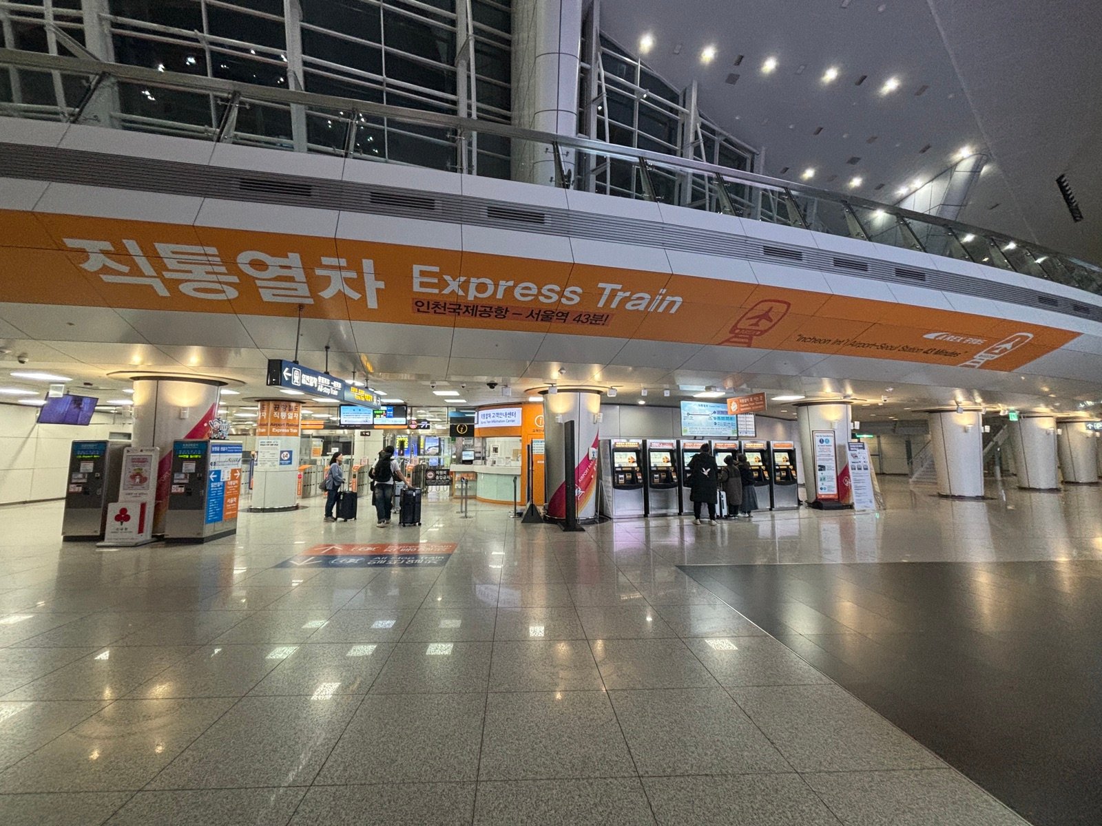 AREX railway concourse at Incheon Airport Terminal 1 with an orange Express Train banner